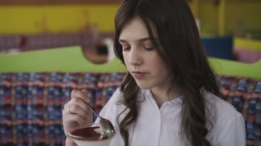 Kafede lezzetli tatlı yeme gülümseme ile genç ve güzel kız. 4k