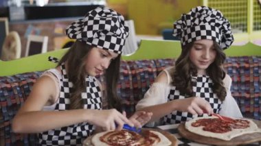 Kafede 4 k ana sınıfı üzerinde pizza pişirme üniformalı iki neşeli kız