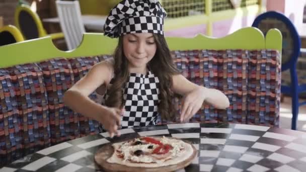 Dos muchachas alegres en uniforme que cuecen la pizza en la clase maestra en la cafetería 4K — Vídeo de stock