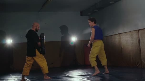 Dos luchadores libres entrenando patadas y recepciones en el gimnasio. Despacio. — Vídeos de Stock