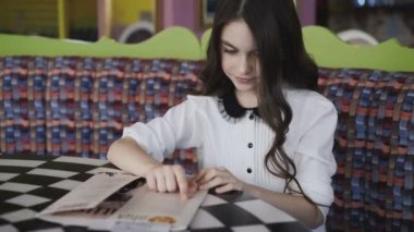 Menüyü okuyan ve bir emir yapma güzel kız. 4k