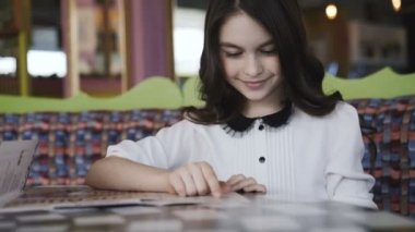 Menüyü okuyan ve bir emir yapma güzel kız. 4k