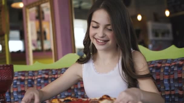 Usmívající se dívka otáčí a obdivovat pizzu prezentace v kavárně. 4k — Stock video
