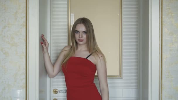 Σαγηνευτικό μπλε-eyed ξανθιά σε κόκκινο φόρεμα που ποζάρει στην κάμερα. 4k — Αρχείο Βίντεο