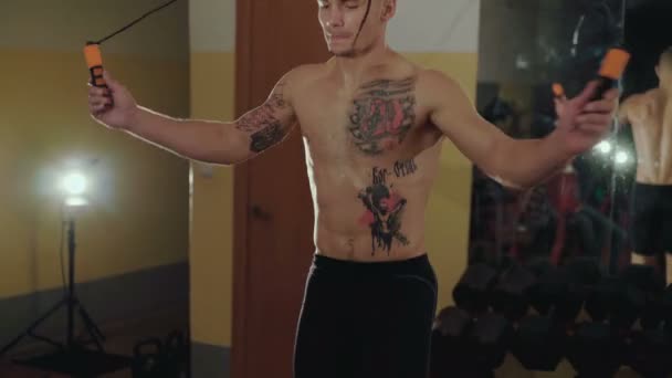 Sem pêlos com tatuagens lutador livre salta com corda no ginásio. 4K — Vídeo de Stock