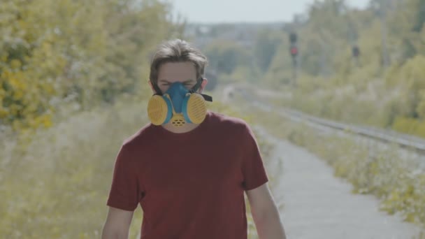 Graffiti-painter in respirator sprays paint on camera — Stock Video