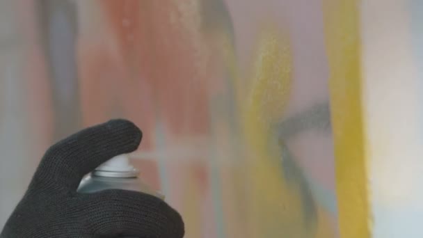 Vue rapprochée de la main en gants noirs dessin graffiti sur mur avec ballon — Video