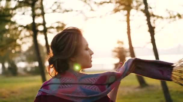 Glad tjej spelar och snurrar med scarf i en solig höst fantastiska park — Stockvideo