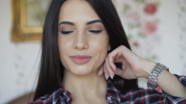 Slimme brunette heeft ontspannen op bed en glimlach op camera — Stockvideo