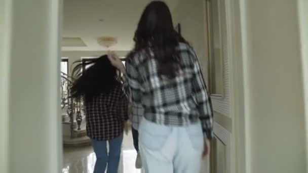 Drie zorgeloos meisjes aangelopen bij trappen in luxe huis. Langzaam — Stockvideo