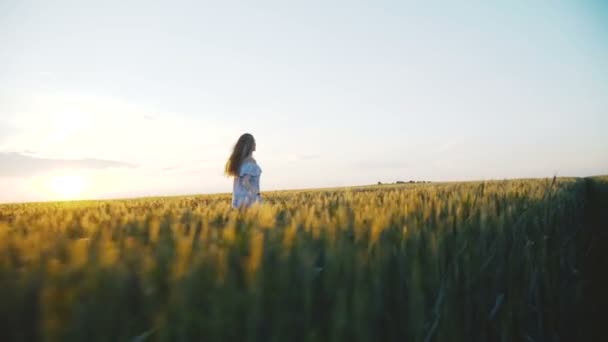 Щаслива дівчина в сукні бігає в зеленому полі молодого зґвалтування — стокове відео