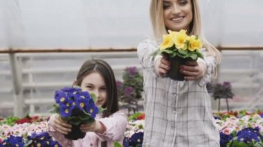 Yetişkin ve Genç kızlar Çiçeklik kamera için germe gülümseyen portresi