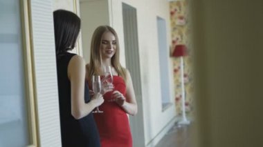 Üç güzel kız elbiseler sahip bir sohbet ve içki şampanya