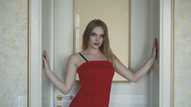 카메라에 포즈를 취하는 빨간 드레스에 매혹적인 푸른 눈 금발. 4 k — 비디오