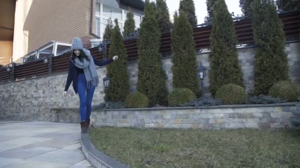 Bella ragazza sorridente in vestiti caldi cammina sul lussuoso cortile. 4K — Video Stock