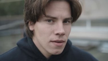 Yakışıklı genç, düşünceli adam kameraya bakan portresi kapatın