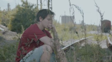 Yolda oturma ve düşünme üzgün genç çocuk. 4k