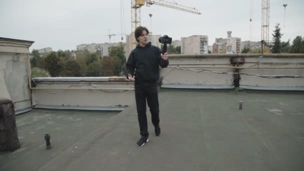 Um repórter bonito a filmar um vídeo sozinho no telhado da rua. 4K — Vídeo de Stock