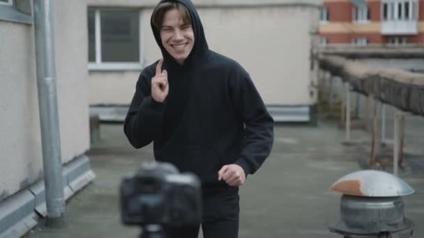 Νεαρό αγόρι δείχνει ένα διασκεδαστικό κινείται για βίντεο κάμερα σε μια στέγη — Αρχείο Βίντεο