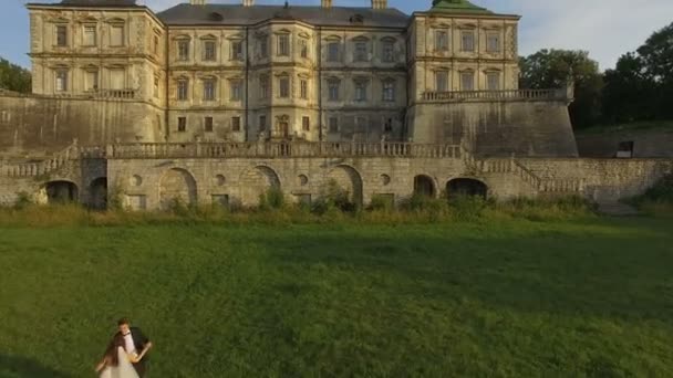 Luchtfoto van bruidspaar dansen op oude kasteel — Stockvideo