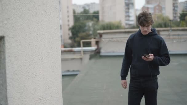 Uomo libero utilizzando smartphone e auricolari e gioire all'aperto — Video Stock