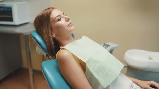 Feliz sonrisa de chica con ortodoncia en silla dental. 4K — Vídeos de Stock