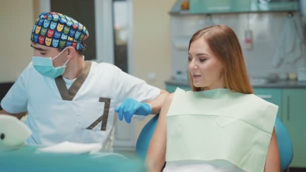 Menina bonita nova está no armário dental no tratamento e consultoria — Vídeo de Stock