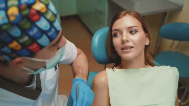 Mladá krásná dívka je v zubní kabinetu na léčbu a poradenskou. 4k — Stock video