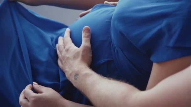 Close up όψη των αρσενικών και γυναικεία χέρια χαϊδεύει μήτρα στην κοιλιά. 4K — Αρχείο Βίντεο