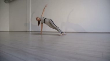 Genç ince kız pratik rahat stüdyoda uzanır. 4k