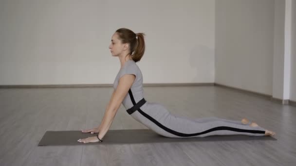 Una chica hermosa y sonriente trabaja en un gimnasio. 4K — Vídeos de Stock