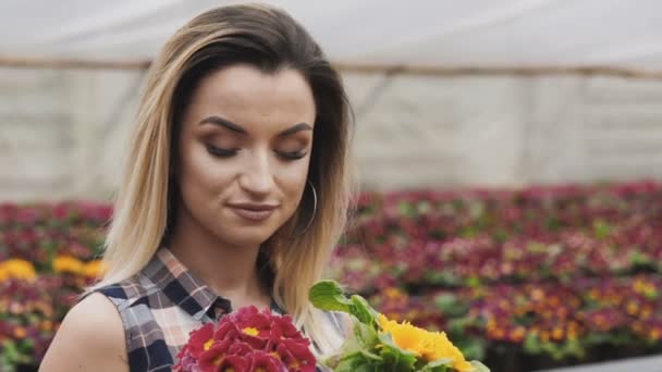 Portrait de jolie fille heureuse montre pot de fleurs à la caméra avec le sourire — Video