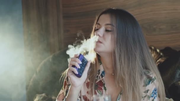 leidenschaftliche Dame, die E-Zigarette raucht und durch Mund und Nase ausatmet
