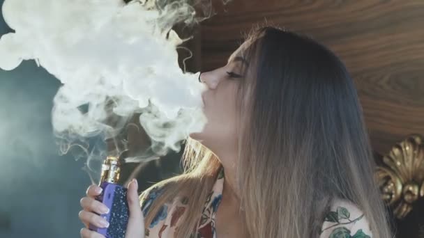 Szenvedélyes hölgy dohányzás e-cigaretta és lélegzik ki a száj és az orr — Stock videók
