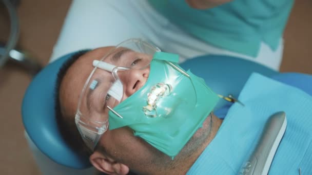 Portret pacjenta z Cofferdam w ustach w gabinecie stomatologicznym. 4K — Wideo stockowe