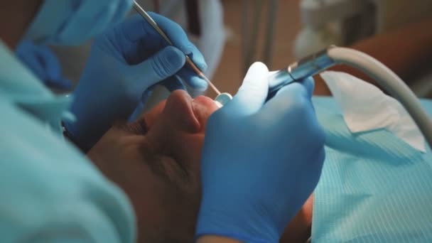 Dentist treats patients teeth with dental drill in clinic. 4K — Stock Video