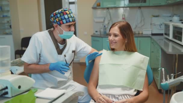 Joven chica bonita está en el gabinete dental en el tratamiento y consultoría — Vídeo de stock