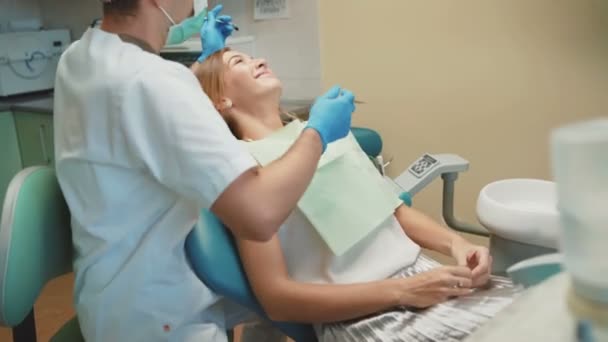 Lächelndes Mädchen und Zahnarzt bei der Vorbereitung auf eine Zahnbehandlung. 4k — Stockvideo