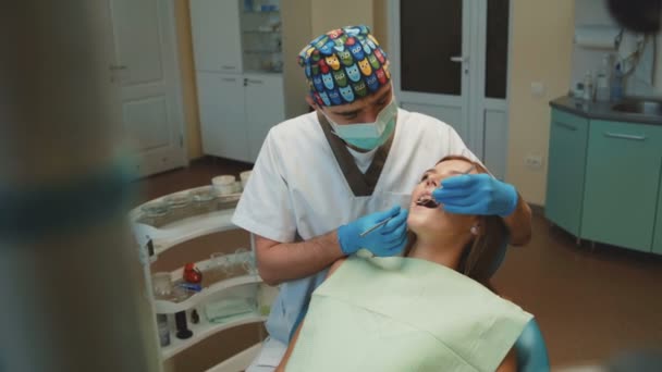 Young pretty girl is in dental cabinet on treatment and consultating — Stock Video