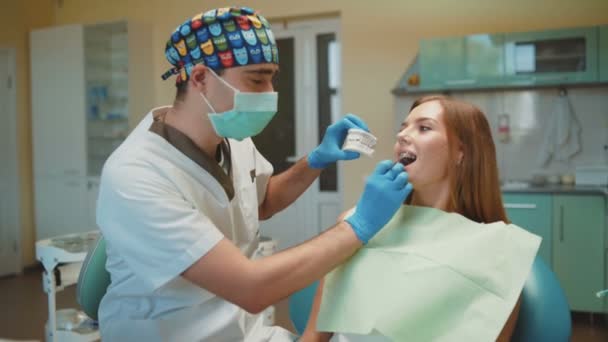 Menina bonita nova está no armário dental no tratamento e consultoria — Vídeo de Stock