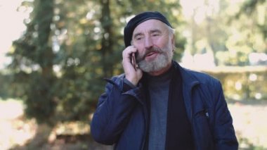 Mutlu kıdemli cep telefonda konuşan ve açık havada sevinir