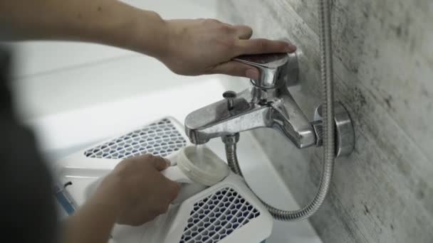 Las manos femeninas ponen la capacidad de aspiradoras bajo el grifo con agua — Vídeo de stock