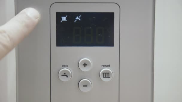 Male finger touches boiler display for temperature control — Stock Video