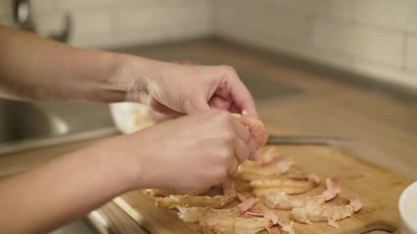 Руки женщины чистят много креветок для приготовления пищи — стоковое видео