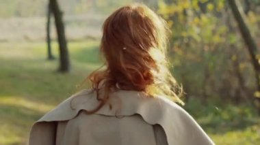 Güzel kız güneşli renkli parkta kızıl saçlı başını sallayarak
