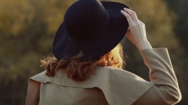 Pretty kız şapka soyunur, başını sallar, gülümsüyor ve kameraya bakar