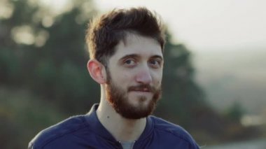 Sakallı, mütevazı bir adamın kızına bakıp doğaya gülümseyen portresi