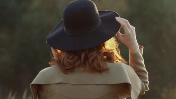 Bella ragazza si spoglia cappello nero e posa con i capelli alla fotocamera — Video Stock