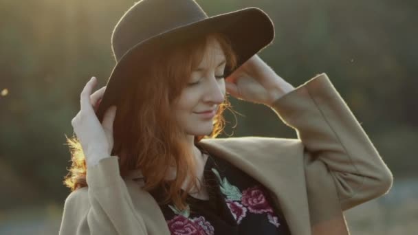 Bájos vörös hajú lány mosolyt arc teszi kalap a fejét, és úgy néz ki félre — Stock videók