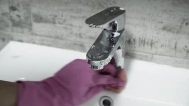 El eldiven banyoda musluk Temizleme. Görünümü Kapat